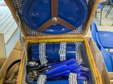 a wicker picnic basket with blue plates and utensils in it