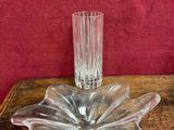 a glass vase on a wooden table with a red wall in the background