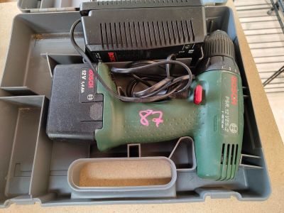 a box with a drill and other tools in it