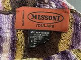 the label of a purple and yellow sweater with a black patch on it