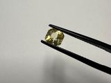 a close up of a pair of tongs holding a yellow diamond