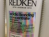 three bottles of redken hair products sitting on top of a wooden table