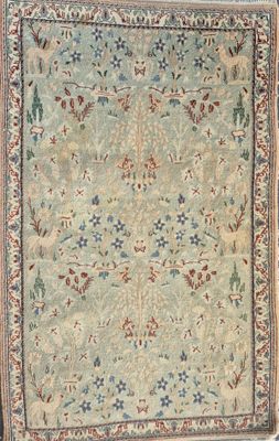 a green and blue rug with a floral design on it