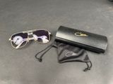 des lunettes de soleil et un étui noir posés sur une table, à côté d'une paire de lunettes