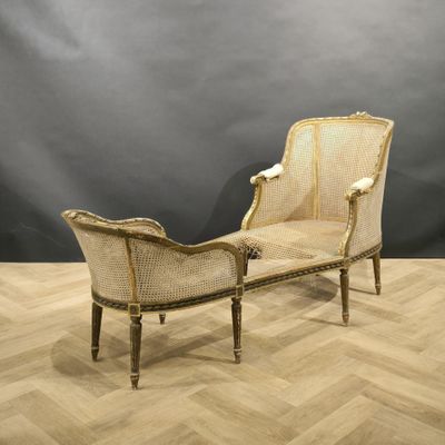 a white and gold chaise lounger sitting on top of a wooden floor