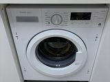 a washing machine in the corner of a kitchen