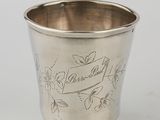 a silver cup with a bird on it sitting on top of a table