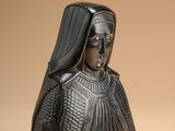 a close up of a statue of a woman wearing a black headdress
