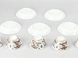 six cups and saucers are arranged in a row on a table
