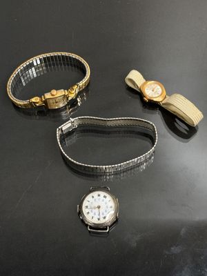 Deux montres et un bracelet sont posés sur une table