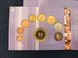 purple booklet with a picture of a child ' s feet and coins on it