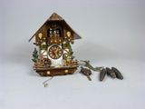 une petite horloge à coucou posée sur la table