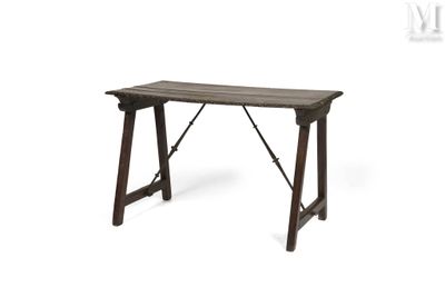 La table est en bois et possède un piètement en métal.