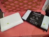 une couverture blanche et un oreiller noir et blanc posés sur une chaise