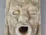 une image représentant une sculpture du visage d'un homme, la bouche ouverte