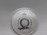 a close up of a silver coin with a clock on it