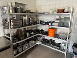 de nombreuses casseroles et poêles sur les étagères de la cuisine
