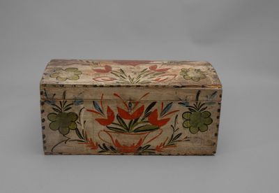 une vieille boîte en bois ornée d'un motif floral