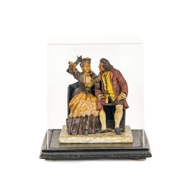 une image représentant une figurine d'un homme et d'une femme assis sur une chaise
