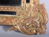 a gold frame with a mirror in it on a table