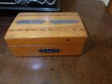 a small wooden box sitting on a table with a clock in the background