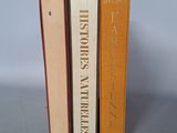 three books are stacked on top of each other on a table