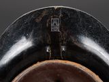 a close up of a black vase with a brown lid