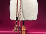 a white mannequin with a rope around it on a wooden stand