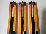 three black and white toothbrushes in a package on a table