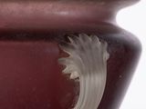 a red vase with a silver handle sitting on a table