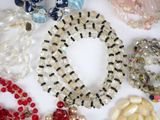 many different types of beaded necklaces and bracelets