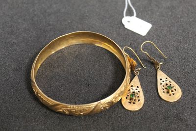 un gros plan d'un bracelet et d'une paire de boucles d'oreilles posés sur une table