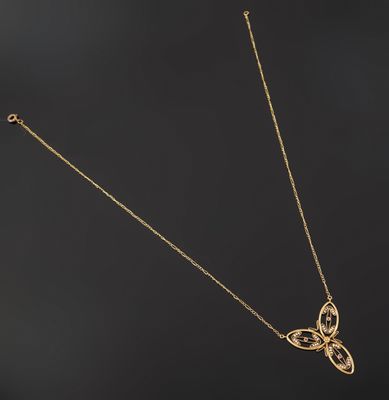 a gold necklace with a butterfly pendant on a black background