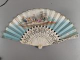 a fan with a painting on it hanging on the wall