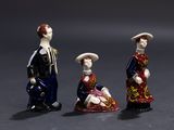 three figurines of people standing next to each other
