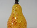 a yellow and red pear sitting on a white surface
