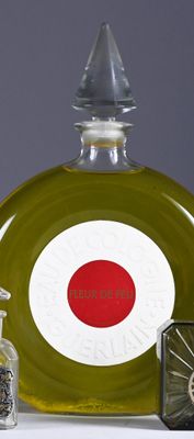 a glass bottle with a red circle on it next to a clock