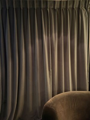 des rideaux dans un salon avec un fauteuil et une lampe