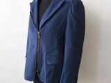jacket on a mannequin stand with a white wall in the background