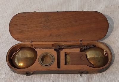 un coffret en bois contenant deux clochettes en laiton