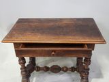 an old wooden table with a drawer on top of it
