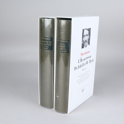 two books sitting on top of each other on a white surface