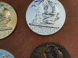 four medals are sitting on a wooden table with a blue case