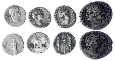 a close up of a group of silver coins on a white surface
