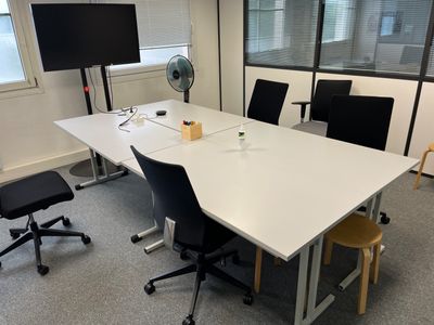 a white table with chairs and a fan in a room