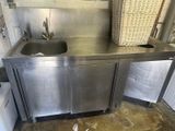 a kitchen with a stainless steel sink and a basket on the counter