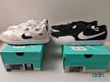 Trois paires de chaussures Nike sont posées sur une table, à côté d'une boîte.