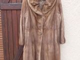 a fur coat hanging on a wall next to a wooden door