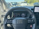 a steering wheel and dashboard of a car in a parking lot