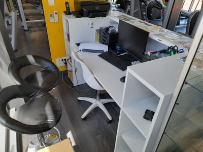 un bureau sur lequel se trouve un ordinateur portable, avec une chaise devant
